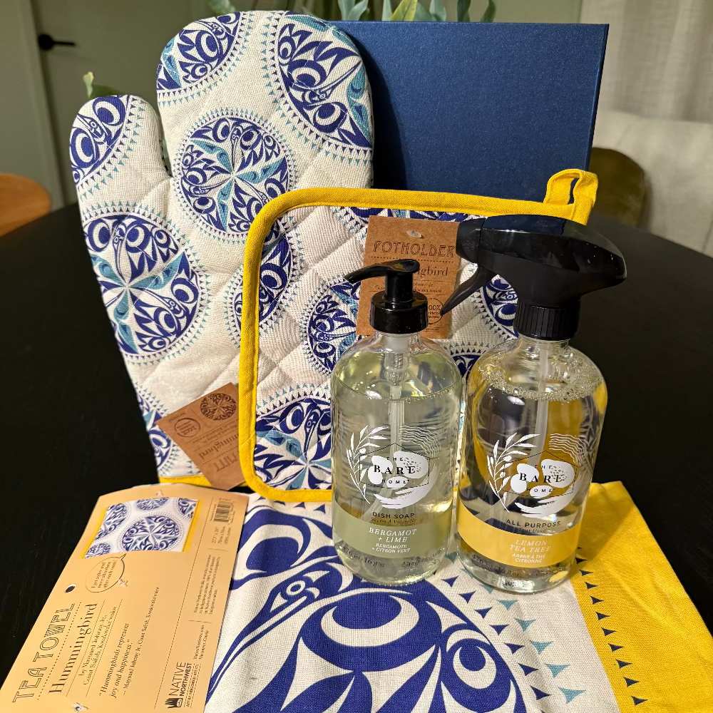 Set of kitchen items including a towel, oven mitt, and two bottles on a table.