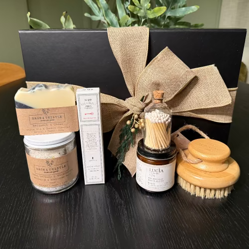 Grooming kit with jars, a brush, and a box on a dark surface.
