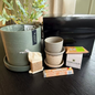 Potted plant, containers, and packaging on a dark surface with visible branding.
